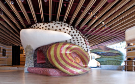 Interior view of 'L'Idiot' restaurant featuring a central sculptural object that reaches the ceiling, standing 3 meters tall and composed of volumes in various shapes, textures and colors. 