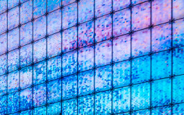 Interior close-up of a façade made up of thousands of unique ceramic printed panels in shades ranging from deep purple to light blue. 